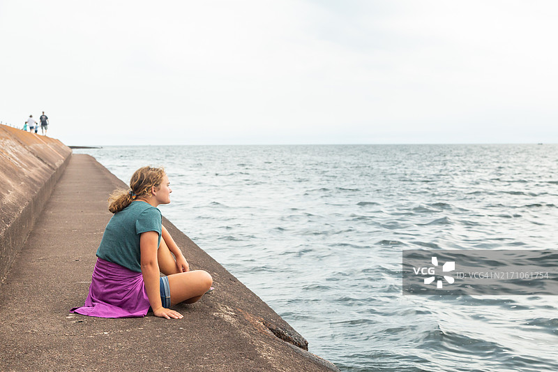 坐在苏必利尔湖码头上的女孩图片素材