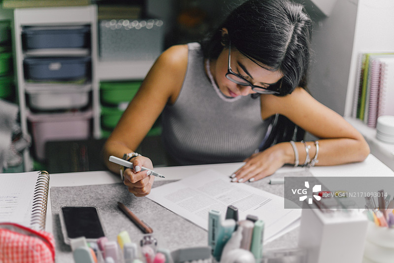 Hispanic男学生在笔记本上写作图片素材