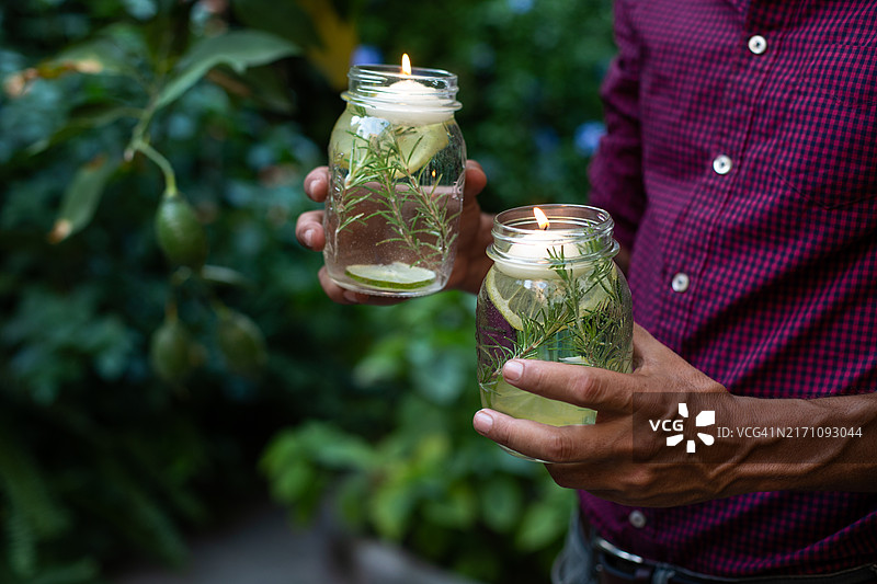 使用柠檬香味漂浮蜡烛作为天然驱蚊剂的男人图片素材