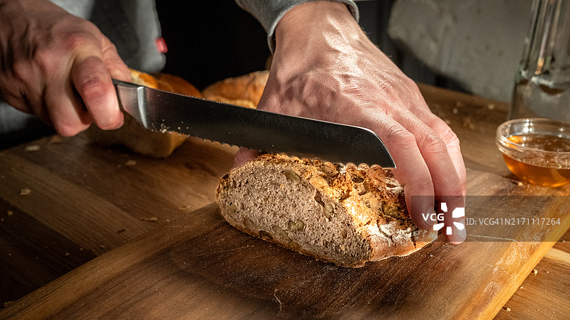 男人在砧板上切面包图片素材