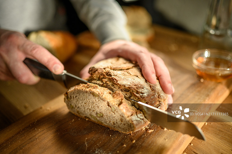 男人在桌子上切面包图片素材