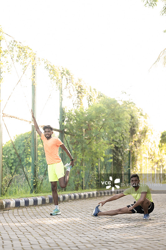 两名男子在户外慢跑后伸展肌肉图片素材