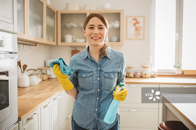拿着喷雾瓶准备清洁的快乐女人图片素材