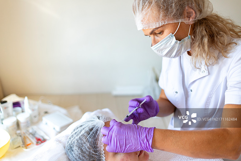 美容师为年轻女人注射玻尿酸补水紧致肌肤图片素材