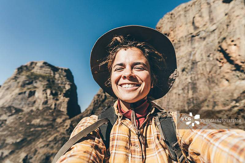 女徒步旅行者欣赏山景并自拍图片素材