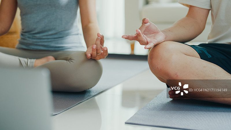 年轻的亚洲夫妇在宁静的家中冥想特写，享受居家健身图片素材