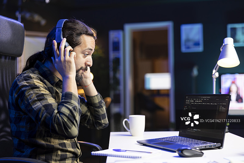 男人戴着耳机检查软件图片素材