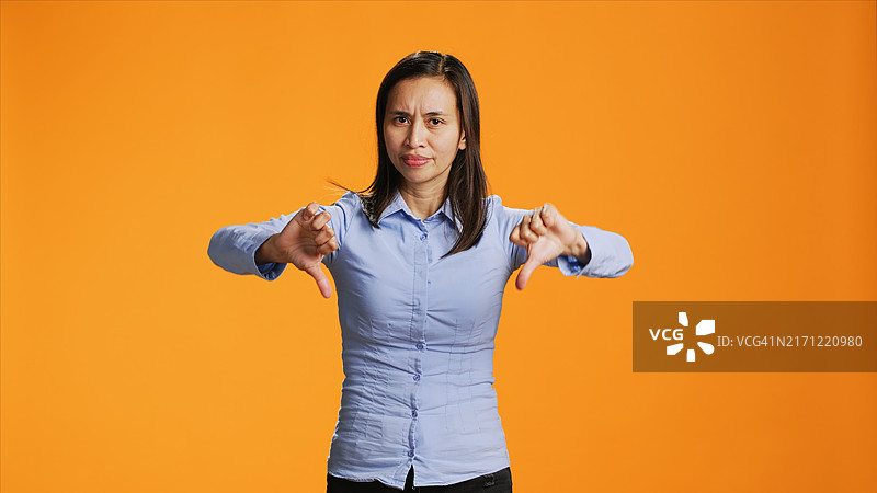 菲律宾女孩对着镜头做拇指向下手势图片素材