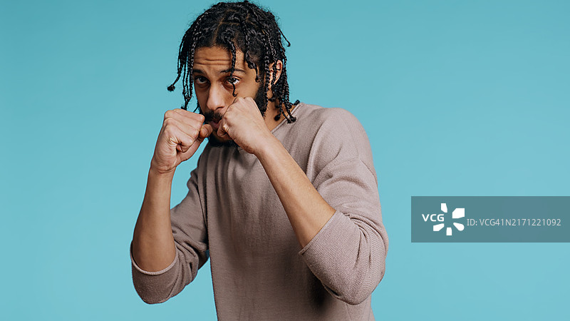 男子出拳，保持防御姿势，工作室背景图片素材