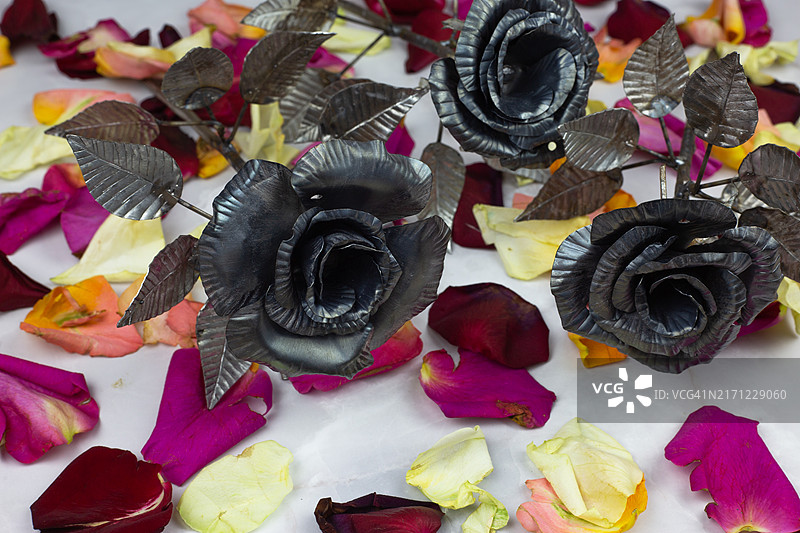 高角度视图的彩色人造金属花朵，花瓣放置在桌子上图片素材