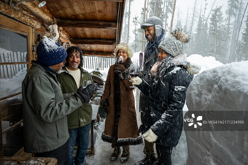 多种族朋友在小木屋外举杯畅饮图片素材