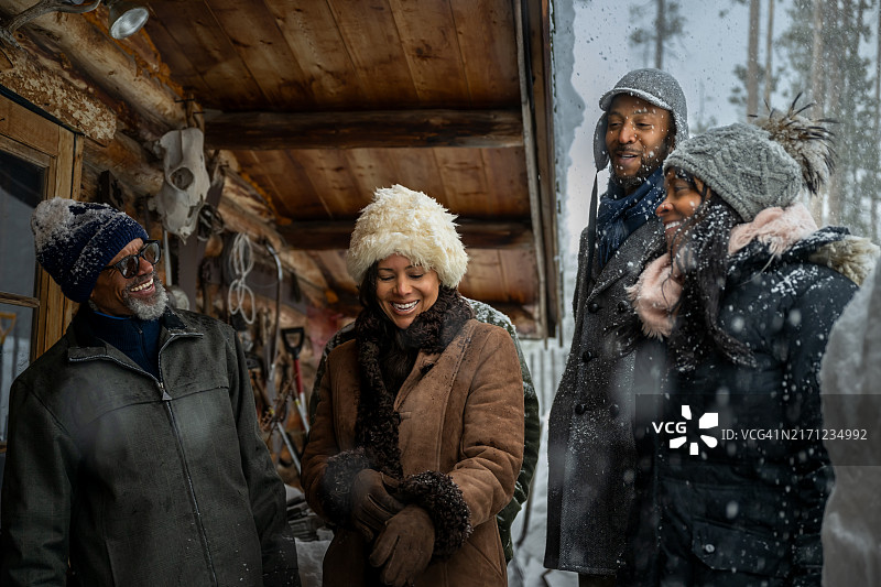 一群非裔美国人在雪天的小木屋外图片素材