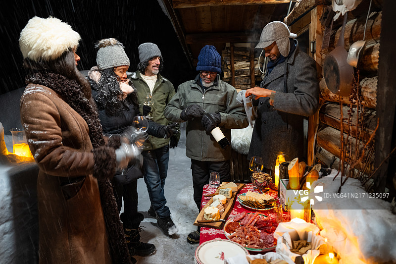 中年非裔美国男人为朋友打开红酒瓶图片素材