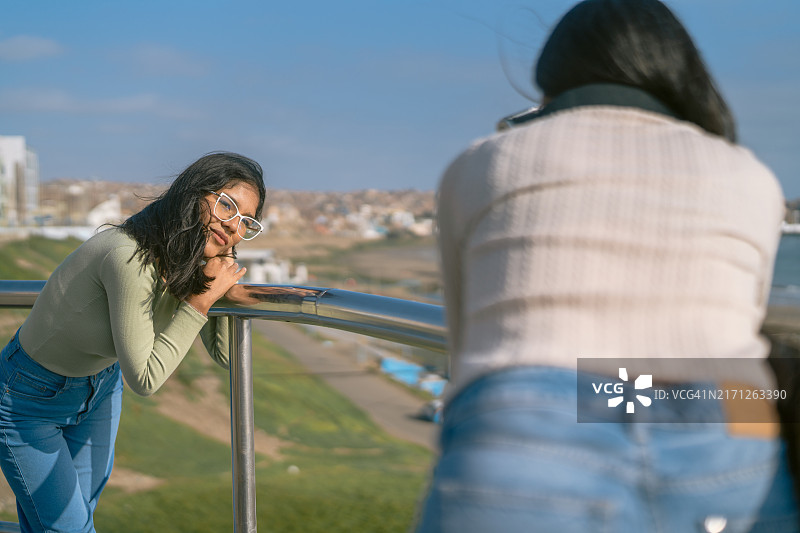 在木板路上拍摄照片的女人图片素材