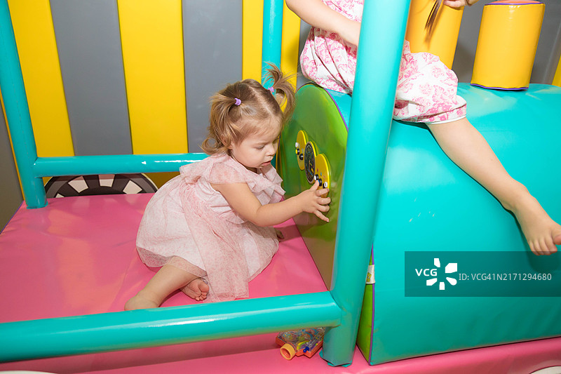 一岁的小女孩在一个大型泡沫火车里玩耍。图片素材