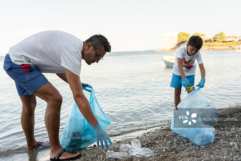 志愿家庭在海边收集废弃垃圾图片素材