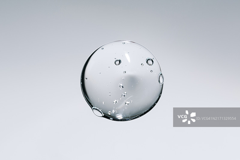 凝胶液滴，带气泡的透明精华液化妆品样品，灰色背景图片素材