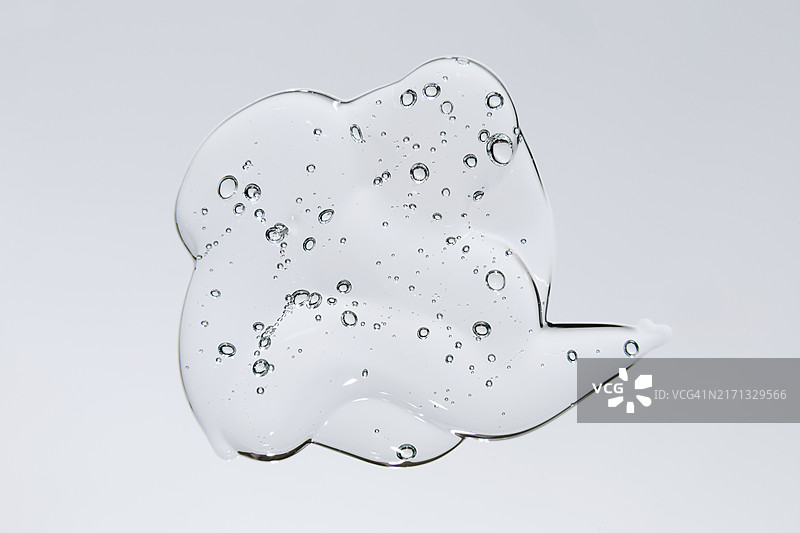 凝胶液滴，带气泡的透明精华液化妆品样品，灰色背景图片素材
