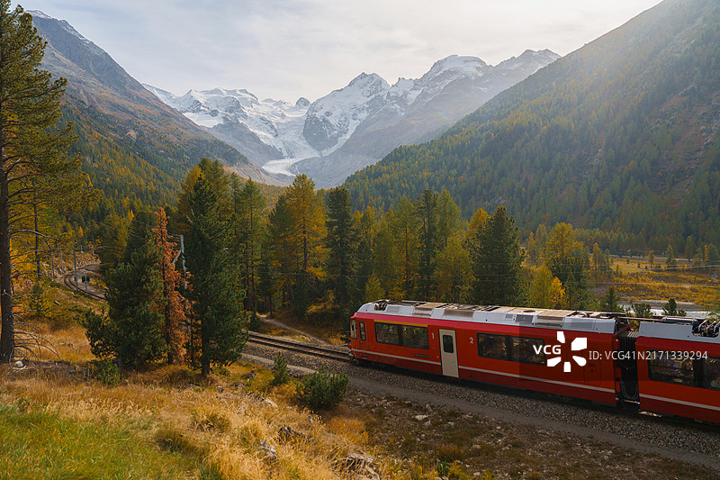 秋季瑞士阿尔卑斯山莫尔特拉奇冰川附近的红色火车图片素材
