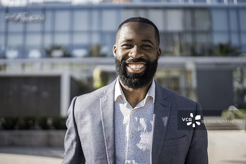 城市背景中微笑的黑人男商人图片素材