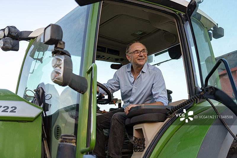 夕阳下拖拉机旁农民图片素材