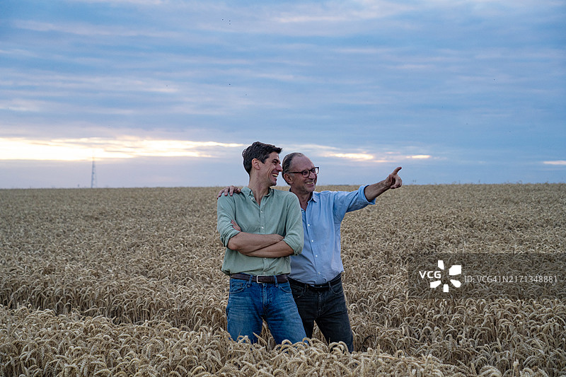 农民和儿子在农田中规划来年作物图片素材