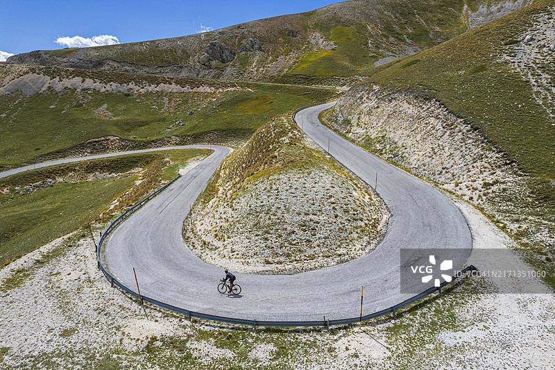 骑自行车的人在山中骑过发夹弯图片素材