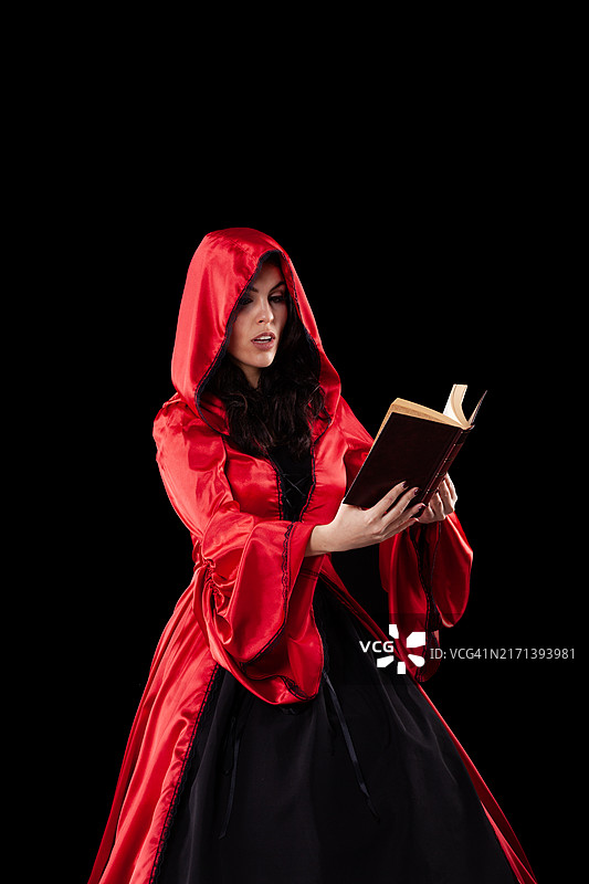 身穿红色带帽斗篷，手拿书本的女人图片素材