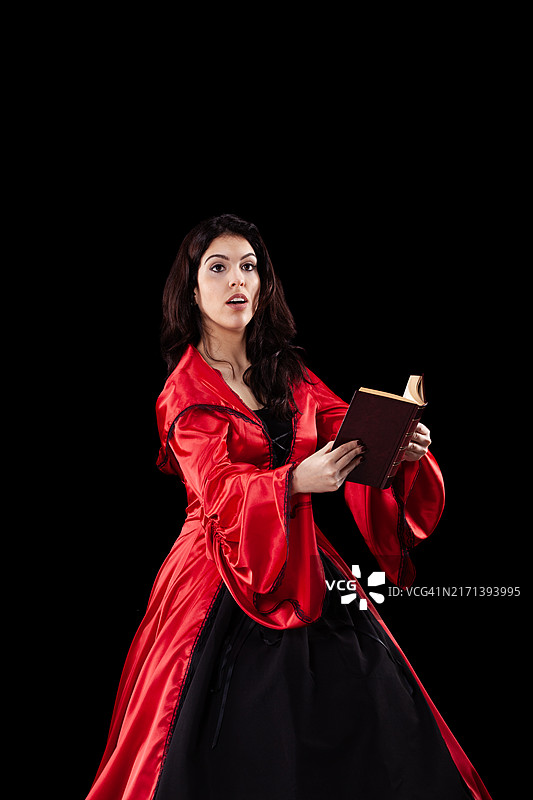 身穿红色带帽斗篷，手拿书本的女人图片素材