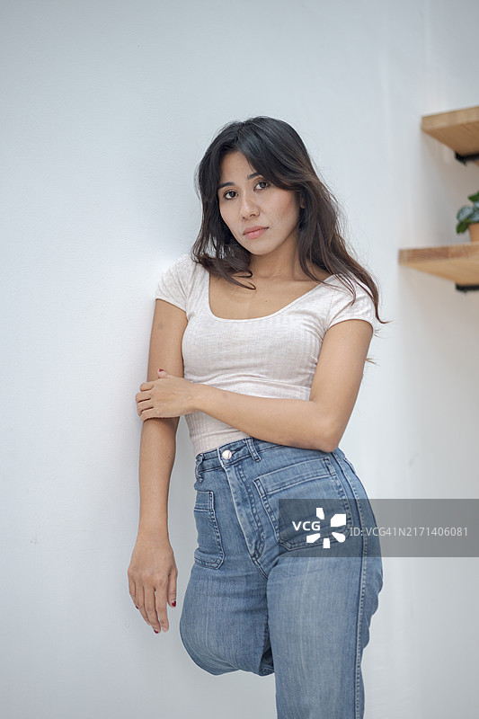 微笑的残疾截肢妇女穿着休闲服装，在白色背景下交叉双臂站立图片素材