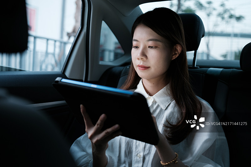 在车里使用平板电脑的白领女人图片素材