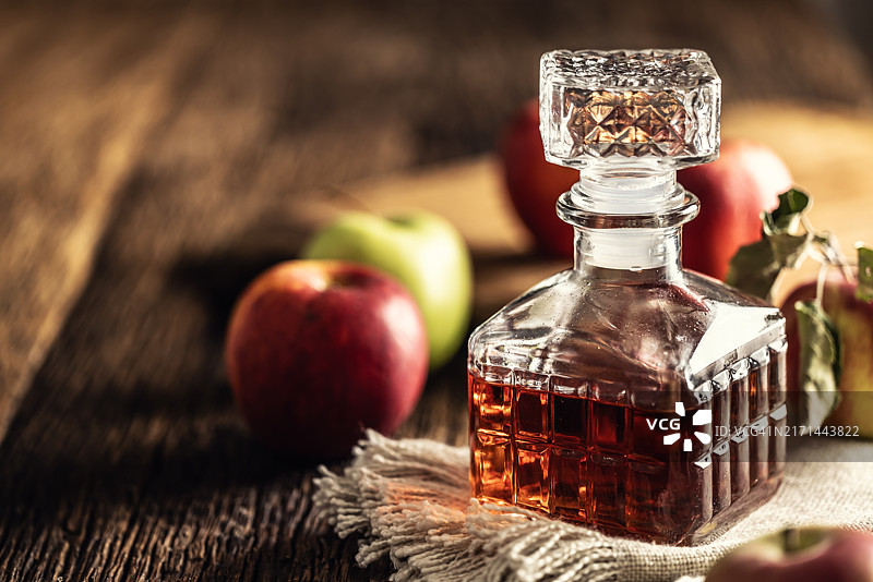 乡村木桌上的苹果醋瓶与新鲜苹果图片素材