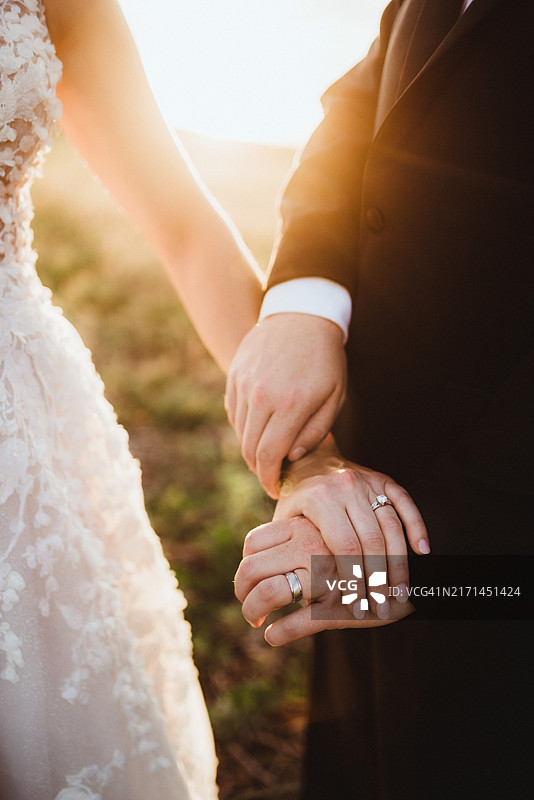 已婚夫妇手牵手，聚焦钻石结婚戒指图片素材