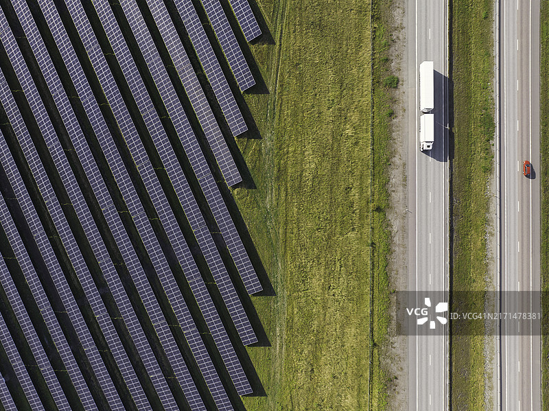 高速公路上的卡车，旁边是大型太阳能发电站鸟瞰图图片素材