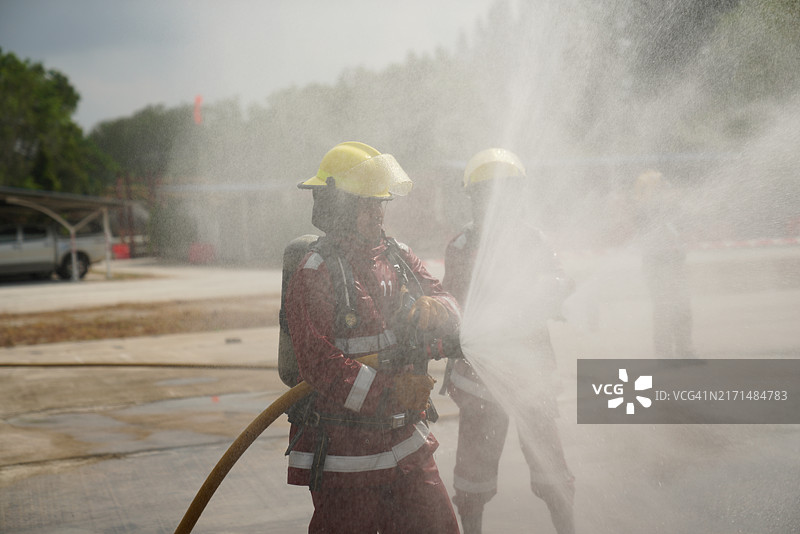 消防员正在喷水以控制工厂内部的火势图片素材