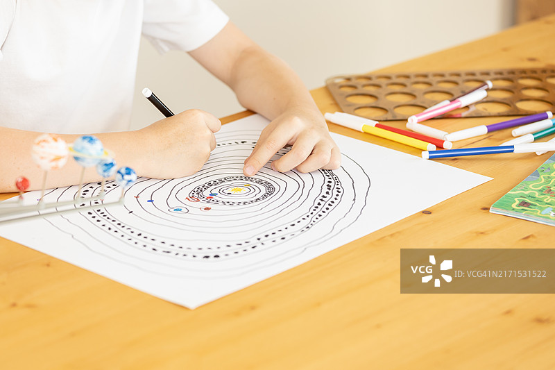 6岁男孩在课堂上绘制太阳系图片素材