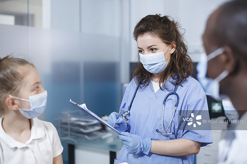 女医生使用平板电脑，背景是女孩图片素材