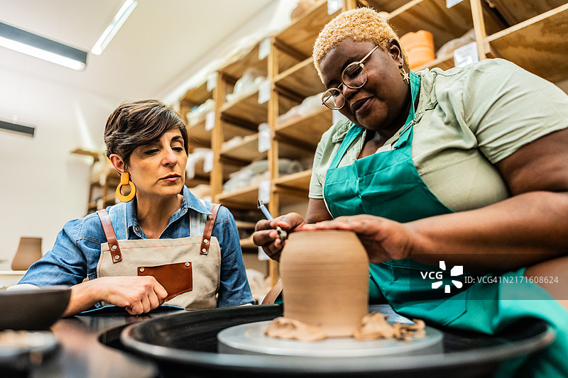 陶瓷工作室里陶艺老师教学生图片素材
