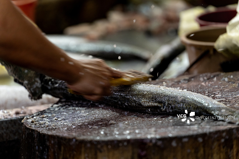 在市场上刮鱼鳞图片素材