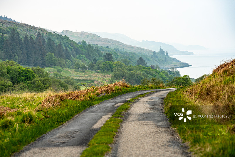 风景秀丽的山丘上的公路，背景为大海图片素材