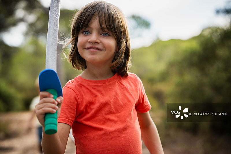 在森林里拿着玩具剑微笑的男孩图片素材