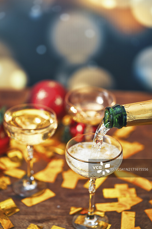 圣诞节假期将香槟倒入香槟杯中图片素材