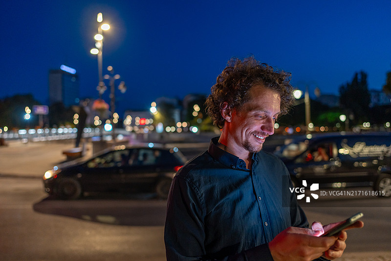 男人在夜晚查看智能手机图片素材