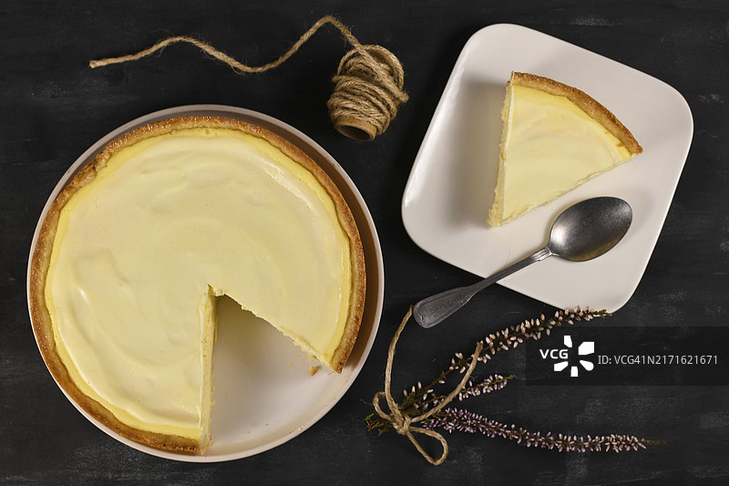 传统纽约芝士蛋糕，奶油芝士和酸奶油层，白色盘子上有一片图片素材