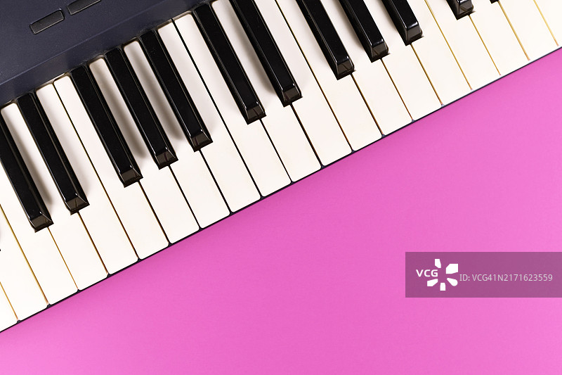 粉色背景上电子琴的琴键，带空白区域图片素材