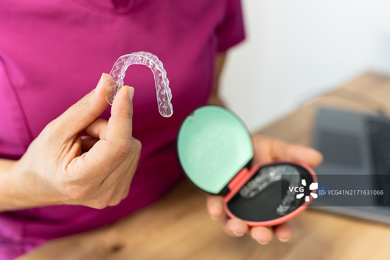 女人手持隐形牙齿矫正器盒图片素材