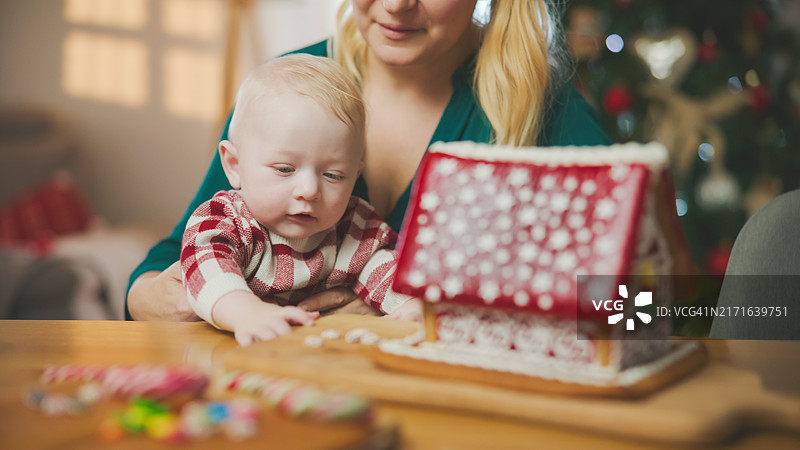 白人母亲和幼儿搭建圣诞姜饼屋图片素材