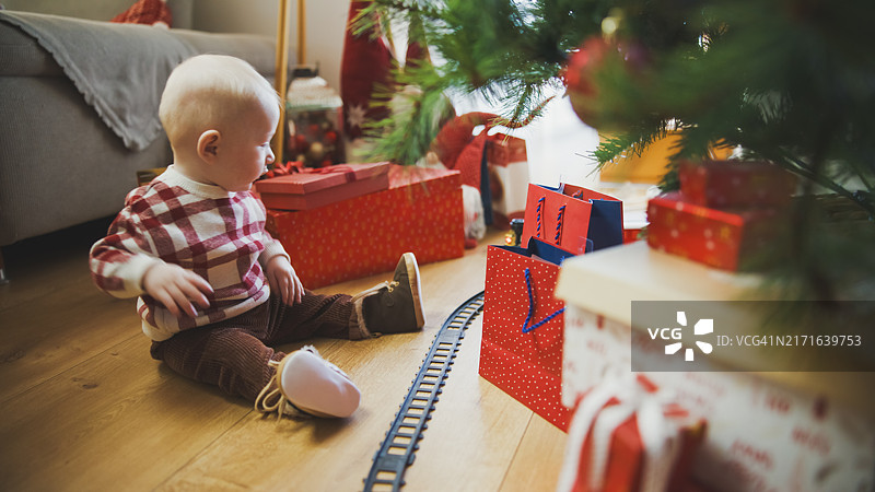 对圣诞火车着迷的好奇男婴图片素材