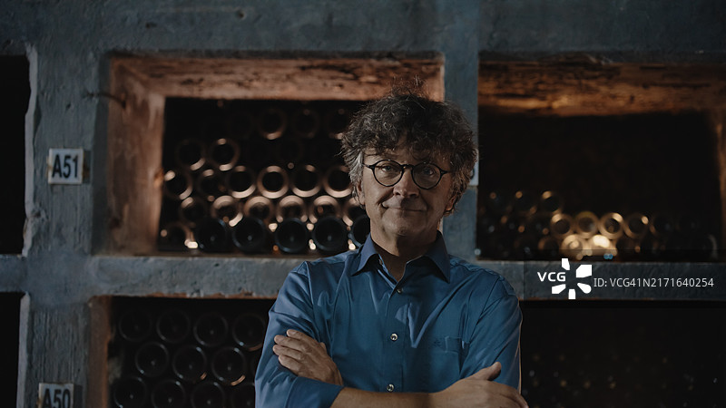 自信的中年男人在酒窖中图片素材