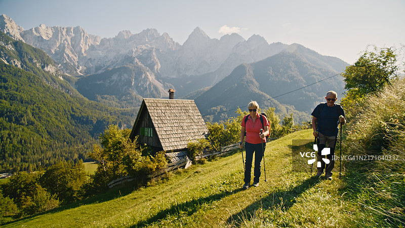 老年夫妇在山间小屋附近徒步旅行图片素材